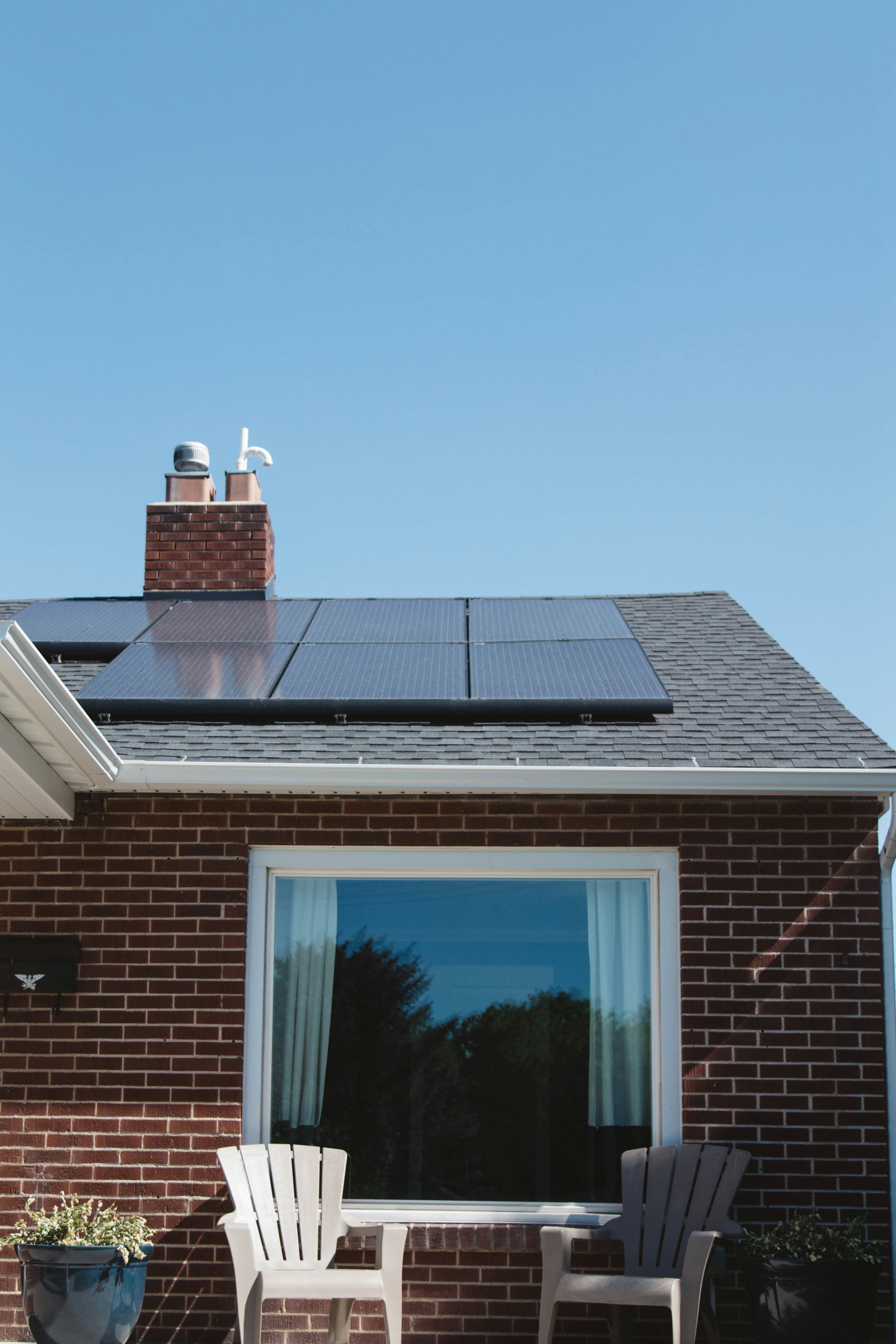 Installation de panneaux photovoltaïques sur une toiture résidentielle avec ciel bleu